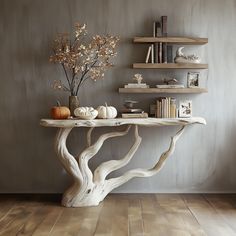 a white table topped with books and vases filled with flowers on top of a hard wood floor