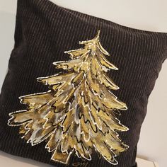 a decorative pillow with a gold christmas tree on it