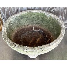 an old stone bowl is sitting on the ground