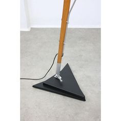 a lamp that is sitting on top of a black base with a wooden pole attached to it