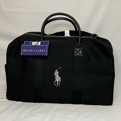 Polo Ralph Lauren Black With White Logo Travel Duffel Leather Straps And High Quality, Thick Canvas Material Brand New In Plastic With Tags Great For Any Occasion!!!! Classic Bags With Embroidered Logo For Daily Use, Classic Rectangular Bags With Embroidered Logo, Black Leather Bag With Embroidered Logo, Black Rectangular Bag With Embroidered Logo, Ralph Lauren Travel Bags With Handles, Elegant Black Ralph Lauren Bags, Ralph Lauren Travel Bag With Dust Bag, Ralph Lauren Travel Bags With Leather Trim, Black Duffel Bag