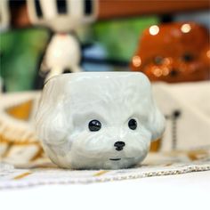 a small white dog figurine sitting on top of a table