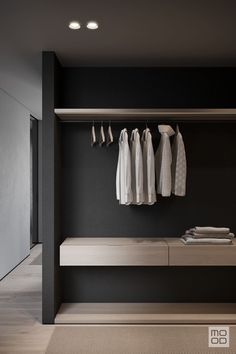 an open closet with clothes hanging on the wall