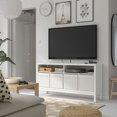 a flat screen tv sitting on top of a white entertainment center in a living room