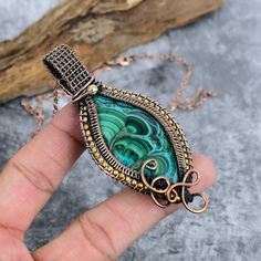 Experience the beauty of nature with our Natural Malachite Gemstone Pendant. Handcrafted with meticulous attention to detail, this stunning piece features a vibrant green malachite stone wrapped in elegant copper wire. The pendant hangs gracefully from a 17"-18" chain, making it a perfect accessory for any occasion. Whether you're looking for a unique gift or a special addition to your jewelry collection, this handmade pendant is sure to impress. Shipping And Handling - Domestic & International Spiritual Green Jewelry With Adjustable Chain, Adjustable Green Artisan Jewelry, Artisan Adjustable Green Jewelry, Green Adjustable Artisan Jewelry, Bohemian Wire Wrapped Teardrop Pendant Jewelry, Bohemian Teardrop Pendant Hand Wrapped Jewelry, Artisan Hand Wrapped Jewelry With Round Pendant, Bohemian Teardrop Pendant Jewelry, Artisan Hand-wrapped Round Pendant Jewelry