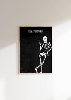 a black and white photo of a skeleton sitting on top of a chair with the words hey pumpkin above it