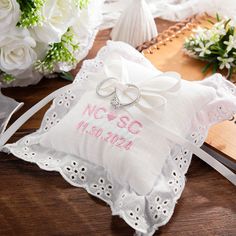 two wedding rings are placed on a ring pillow next to a bouquet of white flowers