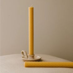 a yellow candle sitting on top of a table