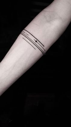 a black and white photo of a person's arm with a line tattoo on it