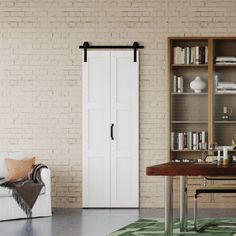 a living room with a couch, coffee table and bookcase in front of a brick wall