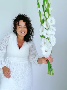 a woman is holding flowers in her hand