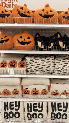 pumpkins and jack - o'- lantern pillows are on display in a store