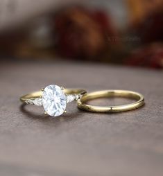 two engagement rings sitting on top of a table next to each other, one with a white diamond in the middle