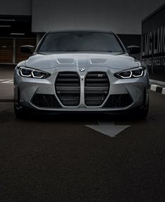 the front end of a silver car parked in a parking lot