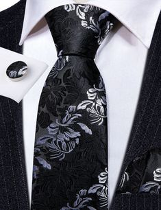 This Black White Floral Silk Tie Pocket Square Cufflink Set is the perfect addition to any formal wear ensemble. Made with high quality silk, this tie features a sophisticated black and white floral pattern that will make a statement at any wedding or special occasion. The set also includes a matching pocket square and cufflinks for a polished, put-together look. 100% Silk Handmade Package Includes: Tie, Pocket Square & Cufflinks. Length: 59" Width: 3.34" Warm iron if needed Luxury Silver Suit And Tie Accessories For Business, Silver Suit And Tie Accessories For Formal Occasions, Silver Elegant Suit And Tie Accessories For Gift, Elegant Silver Suit And Tie Accessories For Gift, Classic Silver Cufflinks For Black Tie Events, Elegant Black Suit And Tie Accessories For Black-tie Events, Black Classic Wedding Cufflinks, Luxury Black Tie For Formal Occasions, Luxury Silver Suit And Tie Accessories For Formal Occasions