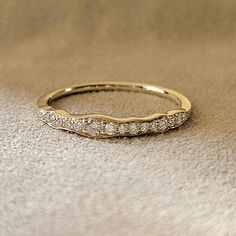 a gold wedding band with three rows of diamonds on the inside and outside of it