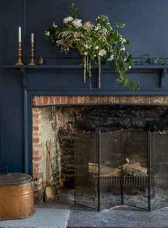 a living room with a fire place and flowers on the mantle