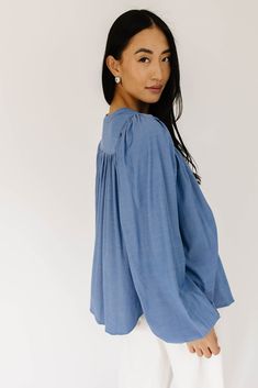 this retro-inspired long sleeve top will take you from summer picnics to fall photoshoots with ease. made with a dark wash denim-esque material, this elevated top features long balloon sleeves + a flowy silhouette. dress it up with trousers + heels, or down with white jeans + sandals. medium wash // high neckline, buttons, balloon sleeves, elastic cuffs paired with our camelot wide leg denim model is 5'8" + wearing a small measurements are approximate + taken while laying flat small : bust 42” l Summer Medium Wash Denim Top With Puff Sleeves, Medium Wash Puff Sleeve Denim Top For Summer, Medium Wash Denim Top With Puff Sleeves For Summer, Spring Casual Puff Sleeve Blouse, Summer Puff Sleeve Denim Top, Blue Summer Blouse With Elastic Sleeves, Summer Blue Blouse With Elastic Sleeves, Billowy Pleated Sleeve Blouse For Spring, Blue Blouse With Elastic Sleeves For Summer