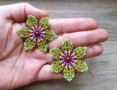 two handmade beaded flower earrings in green and purple