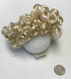 Mini World Vicky Light Blonde Doll Wig. Use this Mini World Vicky Light Blonde Doll Wig to create a doll from scratch or to replace the existing hair!    You can glue or sew in wig. If gluing, we recommend using E6000 or Aleene's Tacky Glue.    What size wig will fit my doll?  To measure your doll head for a wig, use a cloth tape measure that has not been stretched for accuracy. Start the tape at the center of their forehead. Run the tape around, behind one ear to the nape of their neck around to the other ear until the tape meets again at the middle of the forehead. Most wigs have a built in mesh cap that stretches and provides some flexibility in sizing.    Fits dollhead with 8-9 inch circumference. Made of synthetic fiber. Sew In Wig, Mini World, Doll Wig, Cloth Tape, Doll Wigs, Factory Direct Craft, Mesh Cap, Light Blonde, Sew In