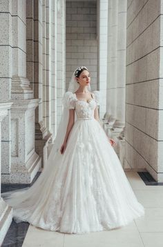 a woman in a white wedding dress standing on the floor