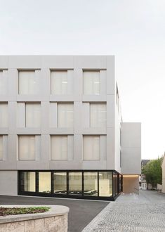 a white building with many windows on the front and side of it's face