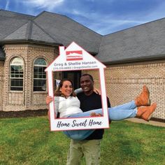 a man and woman holding up a home sweet home sign