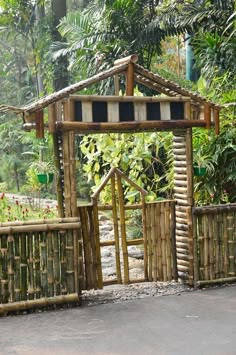 a wooden structure made out of sticks and logs in the middle of a jungle area