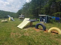 an outdoor playground with swings and slides in the grass