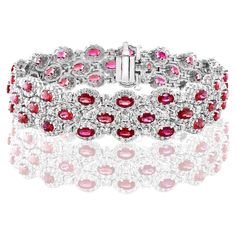 A beautiful vivid red Rubies and Diamond 3-row bracelet showcasing color-rich Rubies, surrounded by a single row of brilliant round diamonds. 51 Oval cut rubies weigh 14.91 carats total; 561 accent diamonds weigh 9.66 carats total. Made in 14k white gold. Style is available in different price ranges. Prices are based on your selection. Please contact us for more information. Red Oval Diamond Gemstone Bracelet, Luxury Red Diamond Bracelet, Luxury Red Diamond Jubilee Bracelet, Red Luxury Diamond Bracelet, Luxury Red Diamond Tennis Bracelet, Red Diamond Oval Tennis Bracelet, Red Diamond Oval Bracelet, Red Oval Diamond Bracelet, Oval Ruby Diamond Bracelet