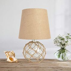 a lamp that is sitting on top of a table next to a potted plant