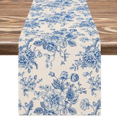 a blue and white table runner with flowers on it