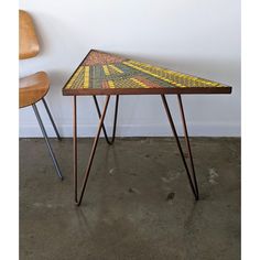 a table that has been made out of tiles and some metal legs on the floor