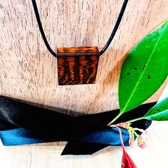 Introducing our exquisite Square Snake Wood Pendant Necklace, a captivating blend of natural beauty and timeless style. Each pendant is meticulously crafted from premium Snake wood, showcasing gorgeous and unique grain patterns that make every piece one-of-a-kind. The pendant hangs gracefully from a 16-inch leather chain, offering a chic and contemporary look that effortlessly complements any outfit. With a range of sizes available, there's a perfect fit for every individual style. Experience the unmatched elegance of our Square Snake Wood Pendant Necklace and elevate your ensemble with its captivating allure. Contact us for custom sizing options to tailor your necklace to perfection. Wood Carving Patterns Necklaces, Minimalist Jewelry In Natural Tones As A Gift, Handmade Wooden Necklace Gift, Artisan Wooden Jewelry As A Gift, Artisan Wood Jewelry Gift, Brown Square Pendant Jewelry For Gift, Artisan Necklaces In Natural Wood As Gift, Artisan Necklace In Natural Wood As A Gift, Artisan Natural Wood Necklace As A Gift