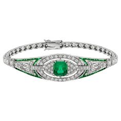 This luminous and luxurious Art Deco style jewel features a center approx. 2.16 carat emerald, framed by approx. 2.16 carat glittering round diamonds and vibrant green French cut emeralds. A slender, streamlined and simply stunning Art Deco design bracelet. Bracelet Information Style: Art Deco Metal: 18K White Gold Width: 16 mm. Length: 55 mm. Weight: 22.15 g. (approx. in total) Center Gemstone Type: Emerald Shape: Octagon Size: 9 x 7 mm. Number: 1 Weight: 2.16 Carat (approx. in total) Accent Ge Art Deco Metal, Green French, Emerald Bracelet, Antique Bracelets, Bracelet Box, White Gold Bracelet, Estilo Art Deco, Gorgeous Jewelry, Diamond Bracelets