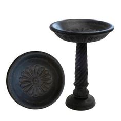 an old fashioned black pedestal with a bowl on the top and a plate below it