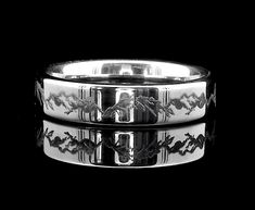 two wedding bands with horses on them are shown in black and white colors, one is engraved into the ring