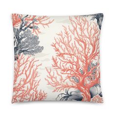 an orange and white pillow with corals on the front, and seaweed in the back