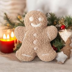 a close up of a stuffed animal near a christmas tree with candles in the background