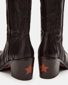 Expertly crafted for Western -style and durability, our SALOON boots feature a pointed toe, knee-high silhouette, and whipstitching detailing. The sturdy block heel with a star detail adds a touch of unique charm while providing comfortable support. Elevate your wardrobe with these timeless, versatile boots.  2.5 inch heel height Size 6 measurements: 14.25 inch shaft circumference, 12.5 inch shaft height Size 8 measurements: 14.75 inch shaft circumference, 12.75 inch shaft height Size 10 measurements: 15.25 inch shaft circumference, 13 inch shaft height   Leather upper material Leather lining Leather sock Synthetic sole Fit tip: If you are in between sizes, size up a half-size Imported Vintage Knee High Boots, Western Witch Aesthetic, Goth Western Style, Edgy Western Style, Black Cowboy Boots, Vintage Cowboy Boots, Western Boots Women, Leather Socks, Leather Wear