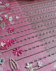 pink and silver beaded fabric with flowers on it