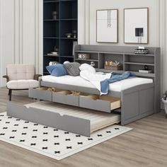 a bed sitting in the middle of a living room next to a book shelf and chair