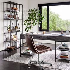 an office with a desk, chair and bookshelf in front of a large window