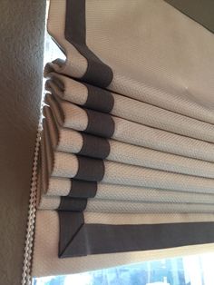 a close up of a window curtain with black and white stripes on it's edges