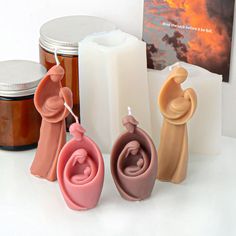 three candles and two figurines on a table