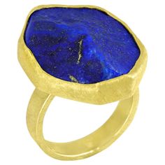 One of a Kind Ring hand-fabricated by master jewelry maker Petra Class showcasing a spectacular extra large 21.0 carat gold-flecked rough lapis lazuli bezel-set in the maker's signature 22k yellow gold atop a textured 18k yellow gold wide band. Stamped and Hallmarked 18k / 22k / PC . Size 6.75 (can be sized). About the Maker - Petra Class acquired her jewelry training in Germany. She spent several years creating tableware, and her approach to her craft is strongly influenced by the European tradition of applied art. Petra’s jewelry is infinitely wearable, communicating her own sensibilities and a contemporary aesthetic. Petra's work reflects definite themes: the rhythmical arrangements of multiple elements; repetition of similar forms or colors; the unexpected contrasts of differently text Blue Lapis Lazuli, Ring Hand, Gold Flecks, Types Of Gemstones, Blue Lapis, Yellow Gold Ring, Jewelry Maker, Wide Bands, Yellow Gold Rings