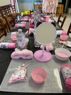 the table is set up for a baby shower party with pink and gray items on it