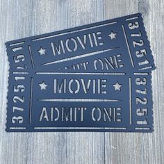 two movie tickets sitting on top of a wooden table