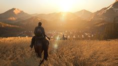 a man riding on the back of a brown horse across a tall grass covered field