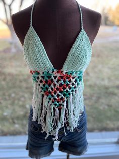 Beautifully handmade crochet bikini top. These look amazing paired with your favorite flannel or just with your favorite shorts and sandals! One size fits most.  The back and top tie so they are very adjustable. The cup size is universal depending on how much coverage you want. This style is very flattering on many different body styles. Color is teal/mint and multicolored orange/white. Can also be made in colors of your choice. Message the shop to create your own colors! Multicolored Crochet Top, Bohemian Green Crochet Beach Top, Bohemian Green Crochet Top For Beach, Green Crochet Top For Beach Season, Hippie Triangle Top For Beach, Green Crochet Bohemian Swimwear, Green Bohemian Crochet Swimwear, Green Crochet Top For Beach Vacation, Handmade Triangle Halter Top For Beach